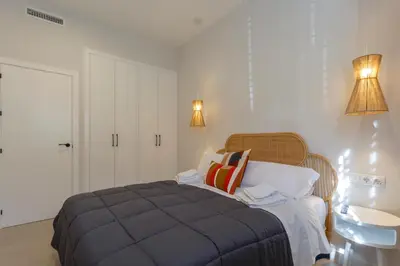 a bedroom with a bed and a sink and two lamps at BAHIA Suites by Cadiz4Rentals in Cádiz