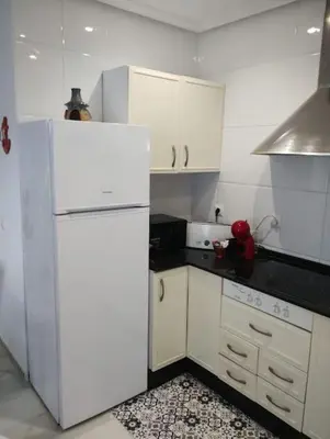 a kitchen with a white refrigerator and white cabinets at La Barrosa, una playa inigualable in Novo Sancti Petri