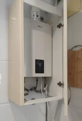 a cupboard with a clock on it in a kitchen at La Barrosa, una playa inigualable in Novo Sancti Petri