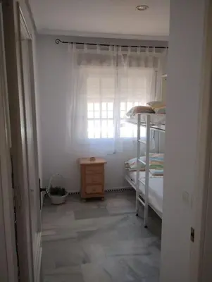 a bedroom with a bunk bed and a window at La Barrosa, una playa inigualable in Novo Sancti Petri