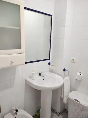 a white bathroom with a sink and a toilet at La Barrosa, una playa inigualable in Novo Sancti Petri