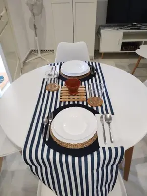 a white table with plates and utensils on it at La Barrosa, una playa inigualable in Novo Sancti Petri