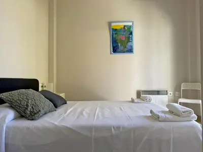 a bedroom with a white bed with towels on it at Villa Al Alba - Ole Solutions in Sanlúcar de Barrameda