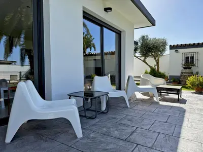 a group of white chairs and a table on a patio at Villa Al Alba - Ole Solutions in Sanlúcar de Barrameda