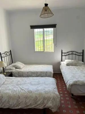 a room with three beds and a window at Rancho-Carita in Bornos