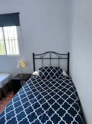 a bedroom with a blue and white bed and a window at Rancho-Carita in Bornos