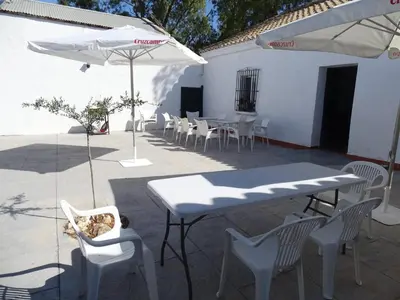 a patio with tables and chairs and an umbrella at Rancho-Carita in Bornos