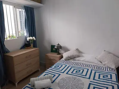 a bedroom with a bed and a dresser and a window at Casatuya in Jerez de la Frontera