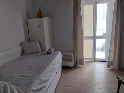 a bedroom with a bed and a white refrigerator at Casatuya in Jerez de la Frontera