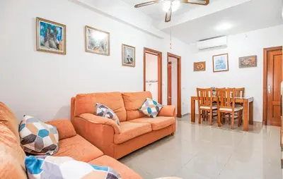 a living room with a couch and a dining room at 2 Bedroom Amazing Apartment In Chipiona in Chipiona