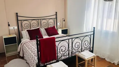 a bedroom with a large bed with red pillows at Una casa en el lago in Arcos de la Frontera