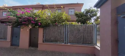 a fence with flowers on top of a building at Preciosa casa a 100 m de Bajo de Guía en Sanlúcar in Sanlúcar de Barrameda