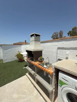 a outdoor grill with a sink in a yard at Casita la ilusión in Conil de la Frontera