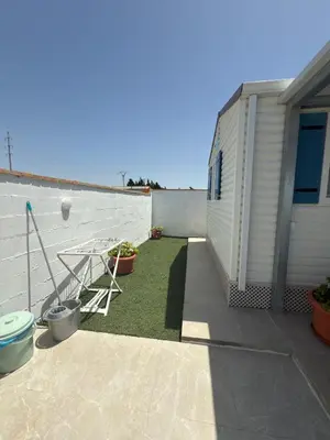 a patio with a table and some plants and a building at Casita la ilusión in Conil de la Frontera