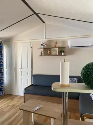 a living room with a blue couch and a table at Casita la ilusión in Conil de la Frontera