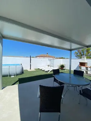 a patio with a table and chairs and the beach at Casita la ilusión in Conil de la Frontera