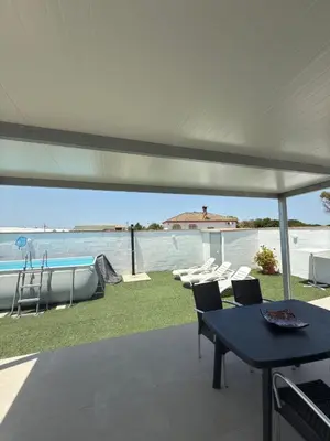 a patio with a table and chairs under a tent at Casita la ilusión in Conil de la Frontera