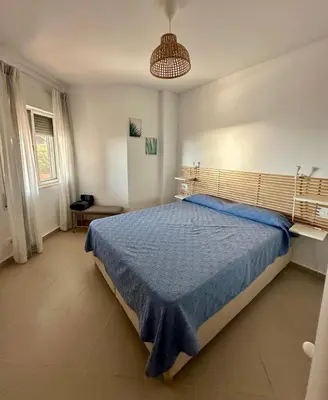 a bedroom with a large bed with a blue bedspread at Ático horizonte in Sanlúcar de Barrameda