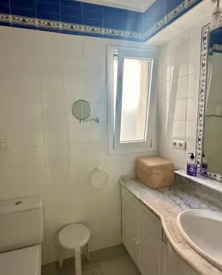 a bathroom with a sink and a toilet and a window at Ático horizonte in Sanlúcar de Barrameda