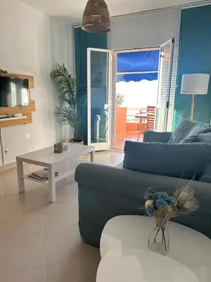 a living room with a blue couch and a table at Ático horizonte in Sanlúcar de Barrameda