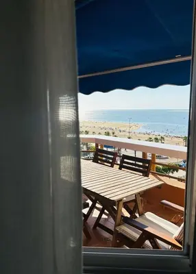 a table and chairs on a balcony with the beach at Ático horizonte in Sanlúcar de Barrameda