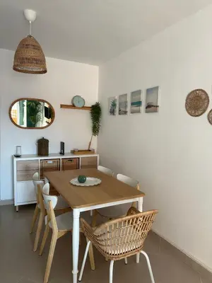 a dining room with a wooden table and chairs at Ático horizonte in Sanlúcar de Barrameda