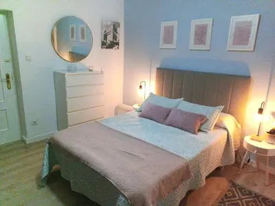 a bedroom with a large bed and a mirror at Villasultana 1 in Chipiona