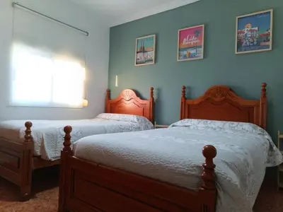 a bedroom with two beds and a window at Villasultana 1 in Chipiona