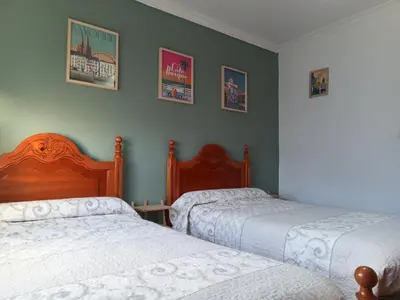two beds in a bedroom with green walls at Villasultana 1 in Chipiona