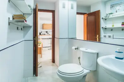 a white bathroom with a toilet and a sink at Precioso apartamento con terraza independiente en pleno centro in El Puerto de Santa María