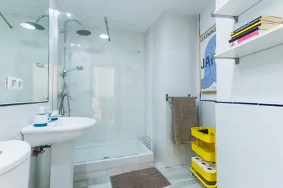 a white bathroom with a sink and a shower at Precioso apartamento con terraza independiente en pleno centro in El Puerto de Santa María