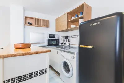 a kitchen with a refrigerator and a washer and dryer at Precioso apartamento con terraza independiente en pleno centro in El Puerto de Santa María