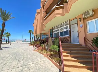 a building with stairs next to the beach at Apartamento Infantes Playa in Sanlúcar de Barrameda