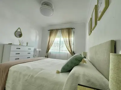 a bedroom with a bed with a green pillow on it at El Cerro de Villasultana, a 3min a pie de playa VUTCA21313 in Chipiona