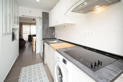 a white kitchen with a stove and a dishwasher at Cimbra 15 in Sanlúcar de Barrameda