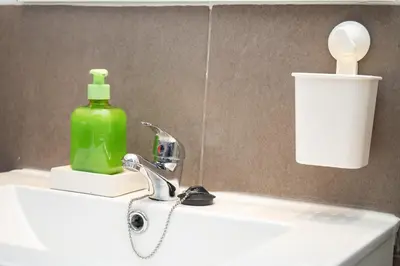a bathroom sink with a green soap bottle on it at Cimbra 15 in Sanlúcar de Barrameda