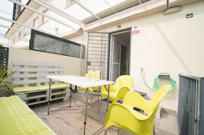 a patio with yellow chairs and a white table at Cimbra 15 in Sanlúcar de Barrameda