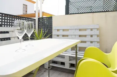 a table and chairs on a balcony with wine glasses at Cimbra 15 in Sanlúcar de Barrameda