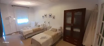 a room with two beds and a chair in it at Acogedor loft a 30 minutos de la playa y montaña in Lebrija