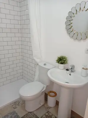 a white bathroom with a toilet and a sink at Acogedor loft a 30 minutos de la playa y montaña in Lebrija