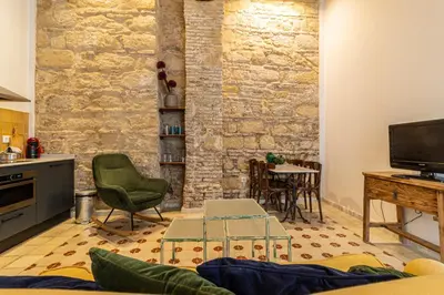 a living room with a stone wall and a tv at Allo Apartments Amargura II Centro Loft in Jerez de la Frontera