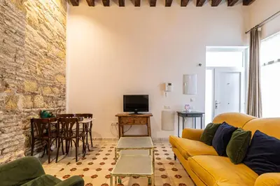 a living room with a yellow couch and a table at Allo Apartments Amargura II Centro Loft in Jerez de la Frontera