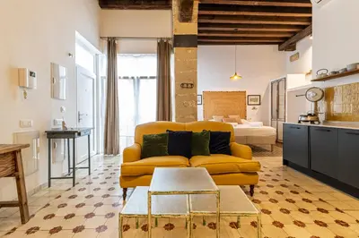 a living room with a yellow couch and a kitchen at Allo Apartments Amargura II Centro Loft in Jerez de la Frontera