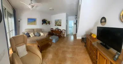 a living room with a couch and a flat screen tv at Adosado Casa Melo Playa la Barrosa La Balconera in Poblado de Sancti Petri
