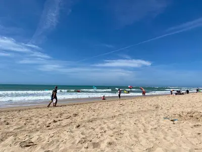 a group of people on a beach flying a kite at Adosado Casa Melo Playa la Barrosa La Balconera in Poblado de Sancti Petri