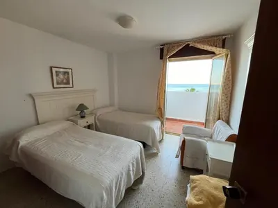 a hotel room with two beds and a window at Apartamento Ana in El Puerto de Santa María