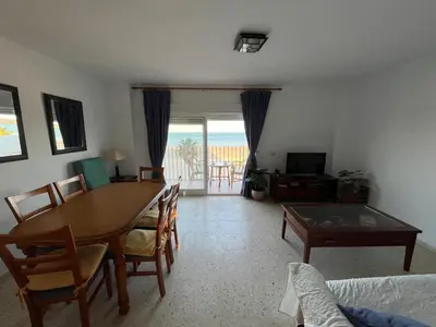 a living room with a table and chairs and a view of the ocean at Apartamento Ana in El Puerto de Santa María