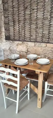 a wooden table with white plates and chairs at Mina25 by 7Escalones in Rota