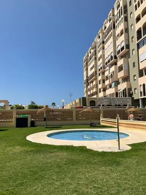 a small pool in a yard in front of some buildings at Azvalia estudio Valdelagrana in El Puerto de Santa María