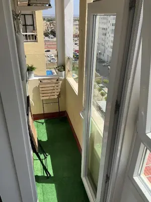 a balcony with a green floor and a window at Azvalia estudio Valdelagrana in El Puerto de Santa María